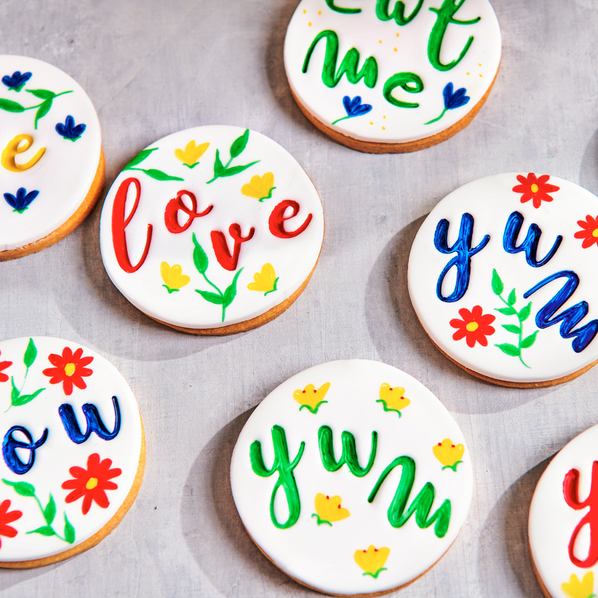 Met FunCakes eetbare stiften versierde koekjes met kleurrijke teksten en bloemen