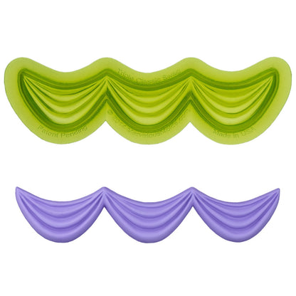 Marvelous Molds swag-mal naast de gemaakte fondant slingers