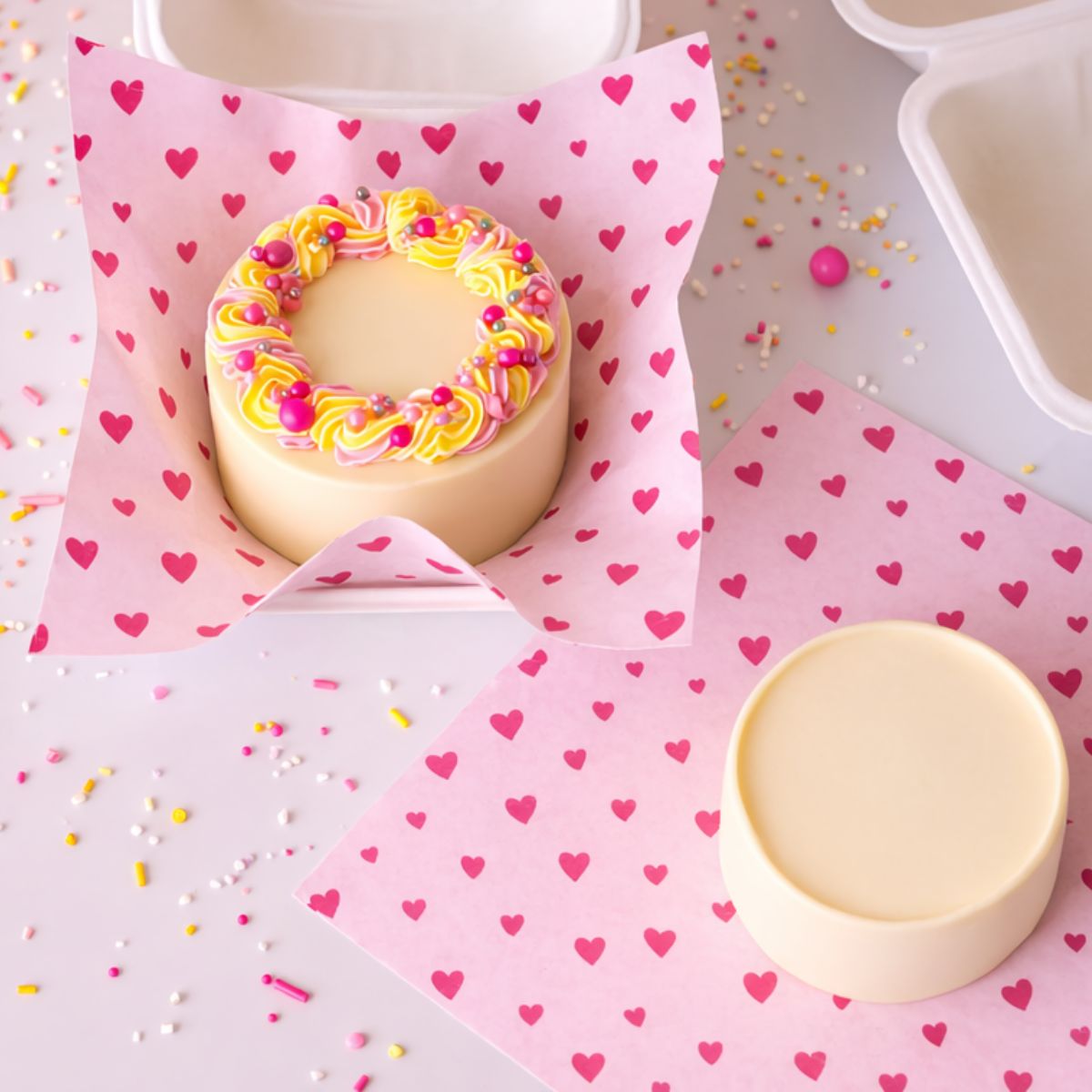 Bento cake op een liner met roze hartjes in een bento box
