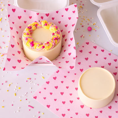 Bento cake op een liner met roze hartjes in een bento box