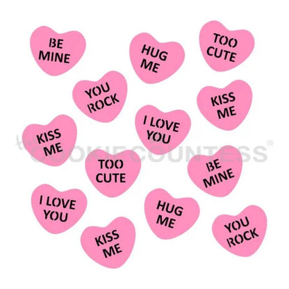 The Cookie Countess 2 Part Conversation Hearts stencil ontwerp met roze hartjes met lieve teksten zoals Be Mine, Hug Me, I Love You, Kiss Me en Too Cute, perfect stencil voor het decoreren van Valentijnsdag koekjes