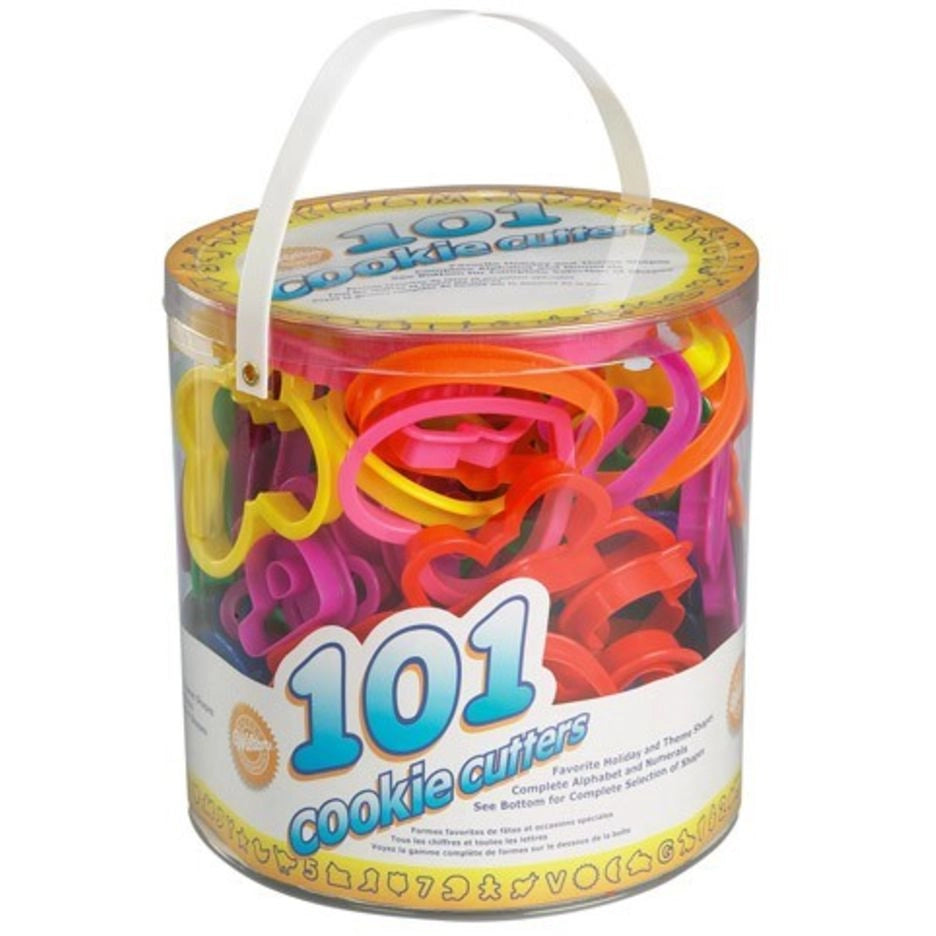 Wilton 101 Cookie Cutters set in doorzichtige emmer met kleurrijke koekjesuitstekers in diverse vormen zoals letters, cijfers en feestdagen thema's