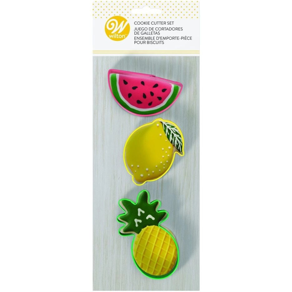 Wilton Cookie Cutter Set Fruit met drie fruitvormige koekjesuitstekers en versierde voorbeeldkoekjes: watermeloen, citroen en ananas, kleurrijke metalen uitstekers voor zomerse koekjes