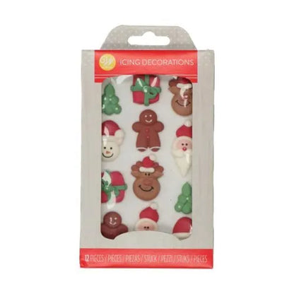 Wilton Kerstfiguurtjes Icing Decorations verpakking met 12 eetbare suikerdecoraties waaronder kerstbomen, peperkoekmannetjes, rendieren, kerstmannen en cadeautjes, perfect voor het versieren van kerstkoekjes en cupcakes